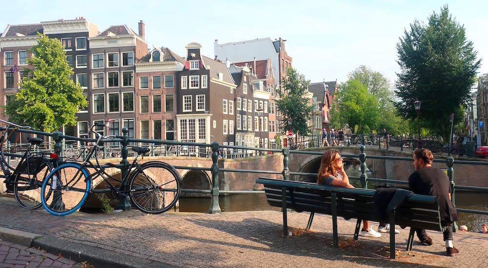 a couple having a date on an Amsterdam street while enjoying the sunlight