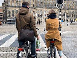 two cyclists waiting for green light on Dam Square in Amsterdam