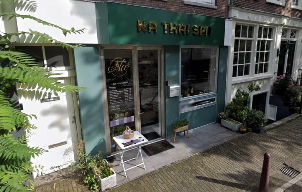 the front entrance of a massage salon in Amsterdam with a sign above the door that states Na Thai Spa