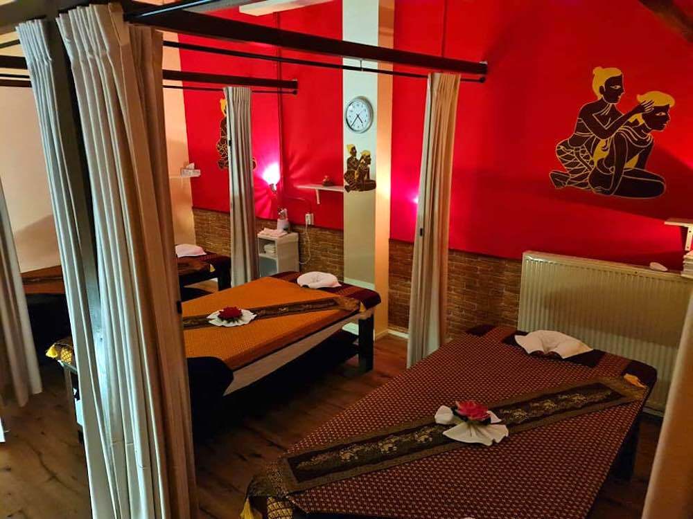 inside of massage parlour Thailand Smile Wellness in Amsterdam that shows three massage beds that can be separated by curtains.